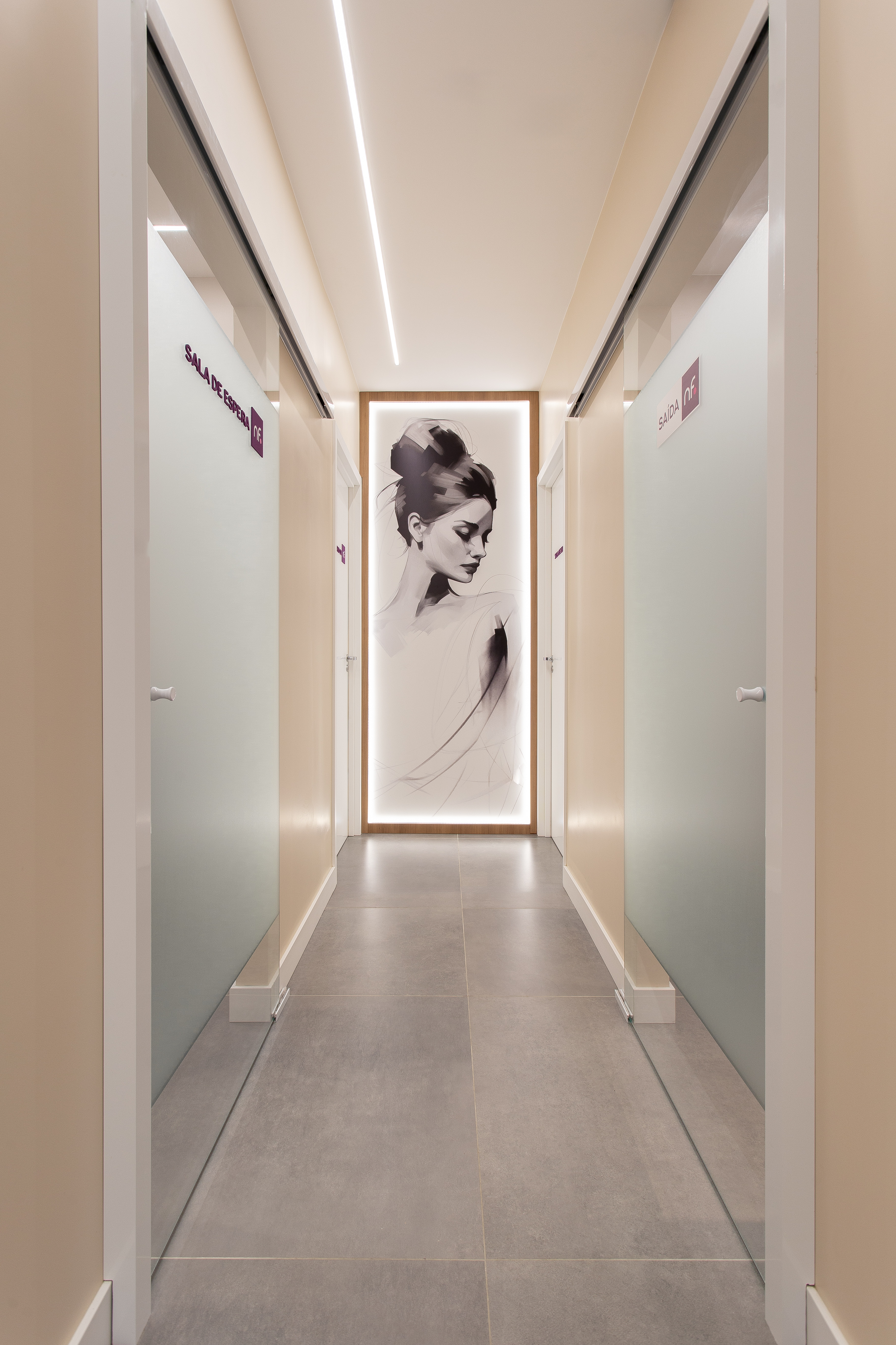 Corredor de clínica médica com iluminação LED e portas de vidro — ATKA Arquitetura